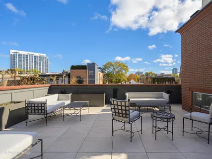 a view of a terrace with furniture and a floor to ceiling window