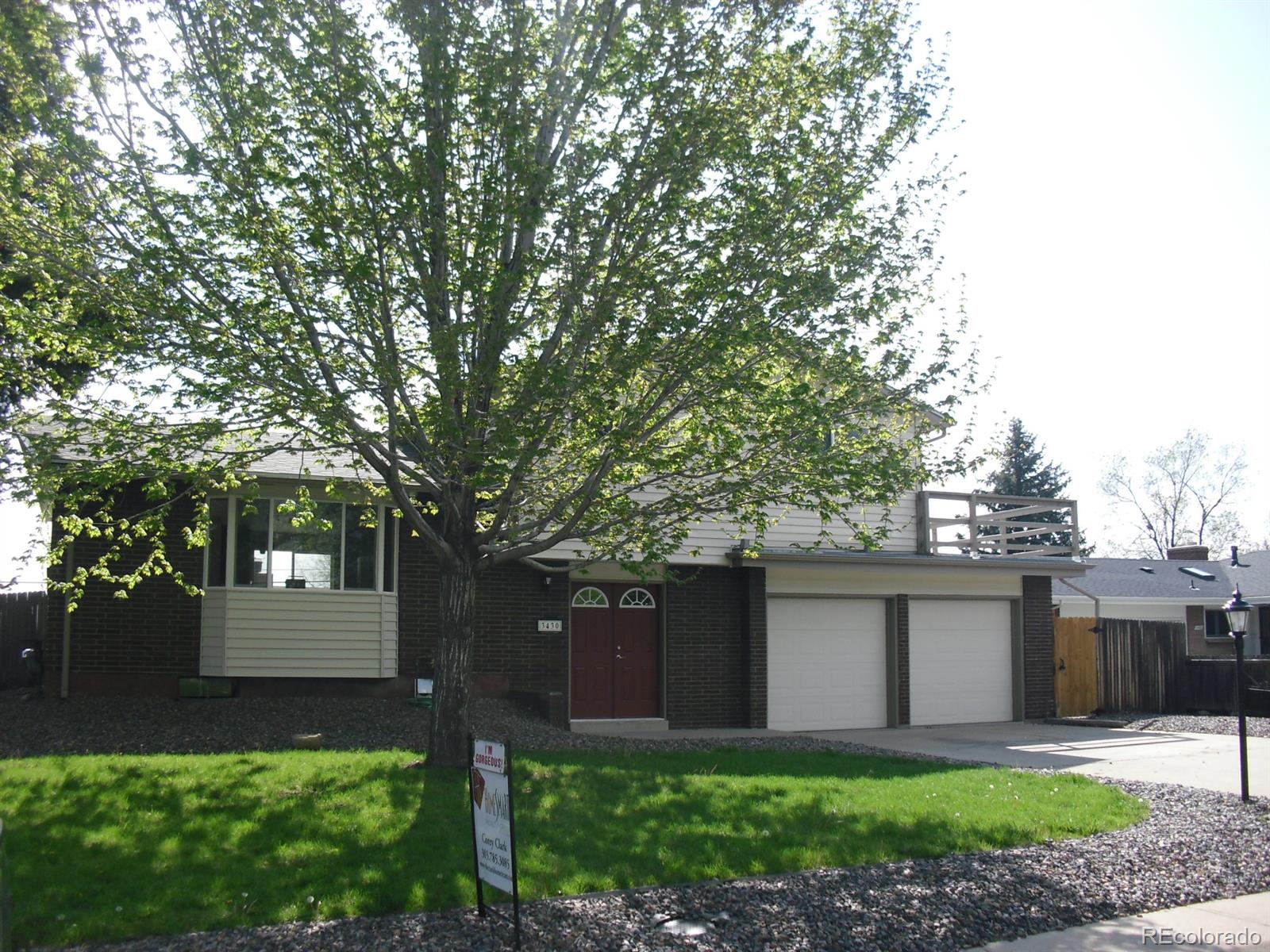3430 Ward Road Wheat Ridge, CO 80033 - Photo 1 of 1 a front view of a house with a yard and a tree