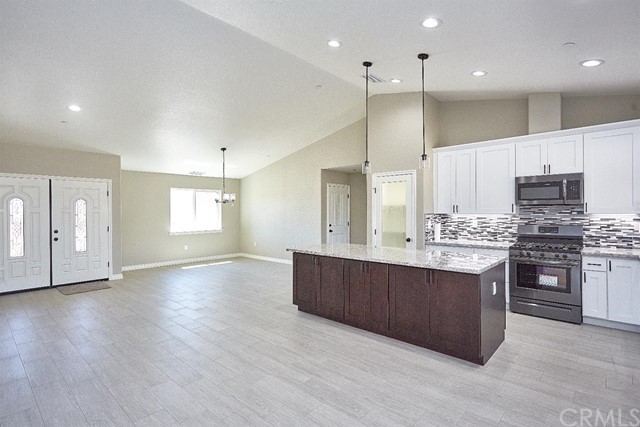 22227 Skyline Drive Apple Valley, CA 92308 - Photo 5 of 34 a large kitchen with stainless steel appliances kitchen island granite countertop a large counter top and stove