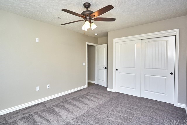 22227 Skyline Drive Apple Valley, CA 92308 - Photo 7 of 34 an empty room with closet and a ceiling fan