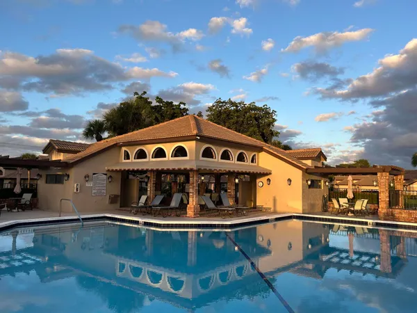 a view of house with swimming pool and outdoor seating