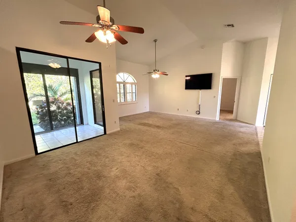 a view of a room with a ceiling fan and a window