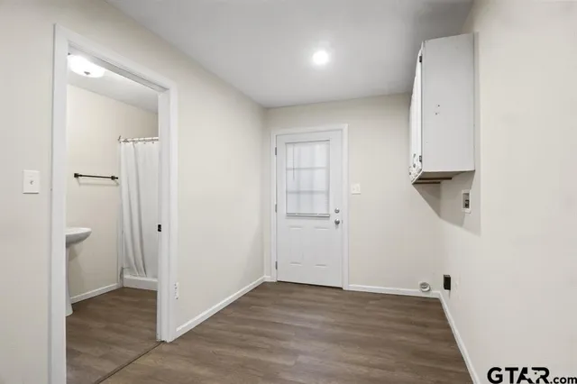 an empty room with wooden floor and a sink