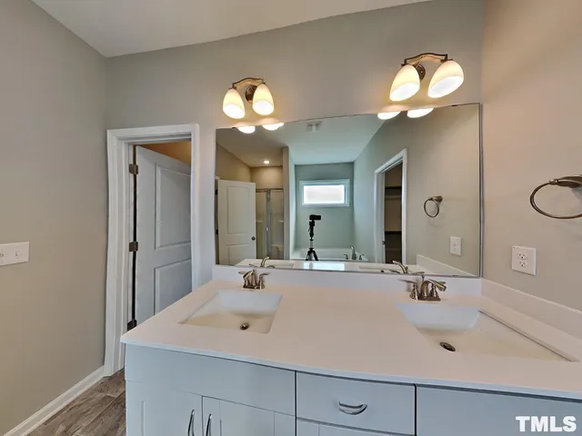 a bathroom with a sink a light fixture and a mirror