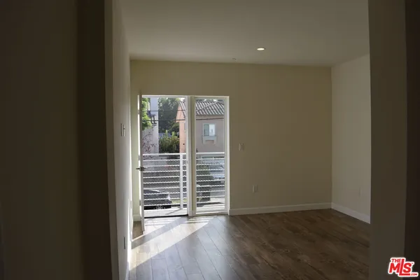 a view of a hallway with wooden floor and a window