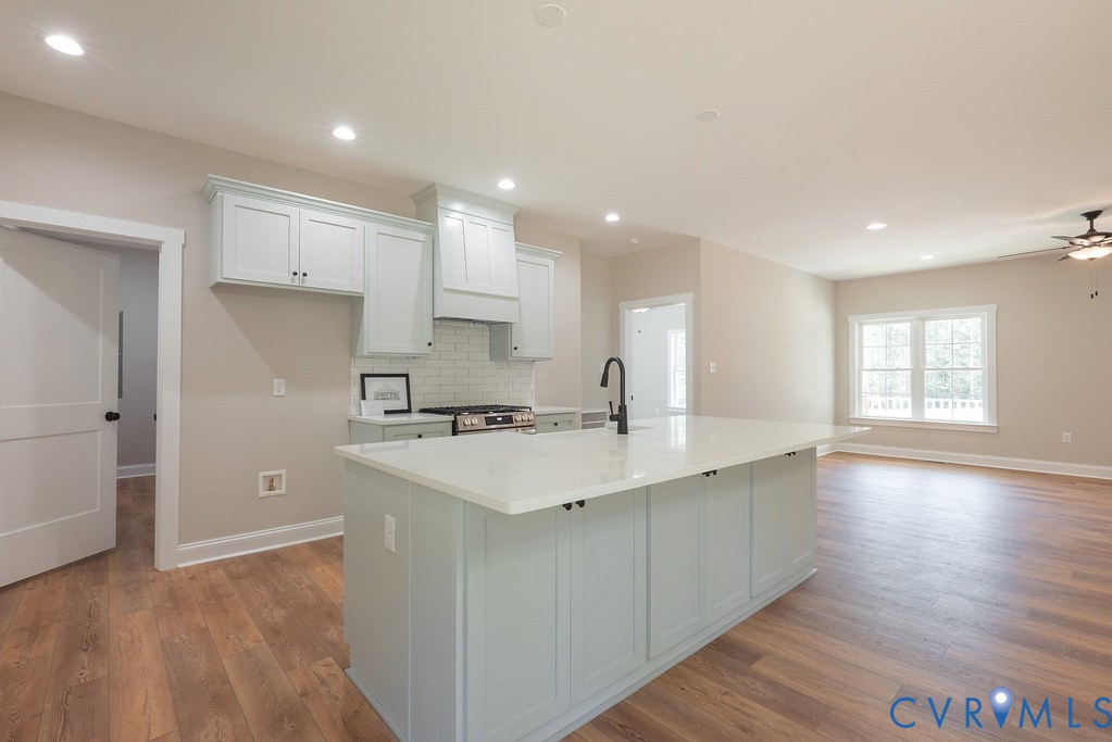5200 Three Chopt Road Louisa, VA 23093 - Photo 43 of 47 a kitchen with a sink a stove a refrigerator and white cabinets with wooden floor