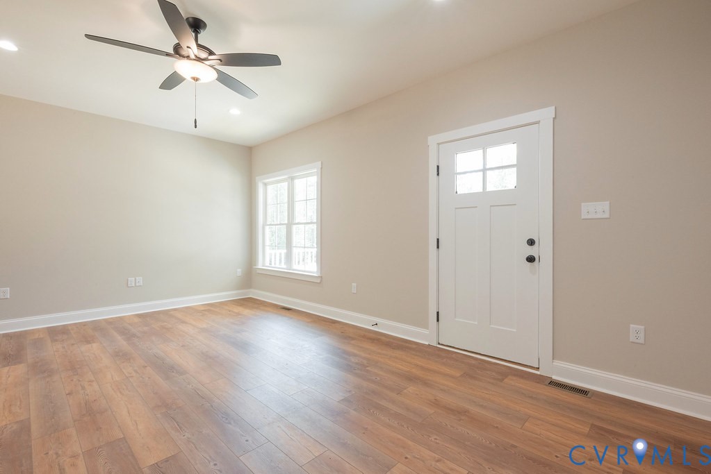 5200 Three Chopt Road Louisa, VA 23093 - Photo 10 of 47 an empty room with wooden floor ceiling fan and windows