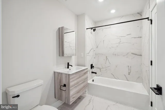 a bathroom with a sink a mirror toilet and bathtub