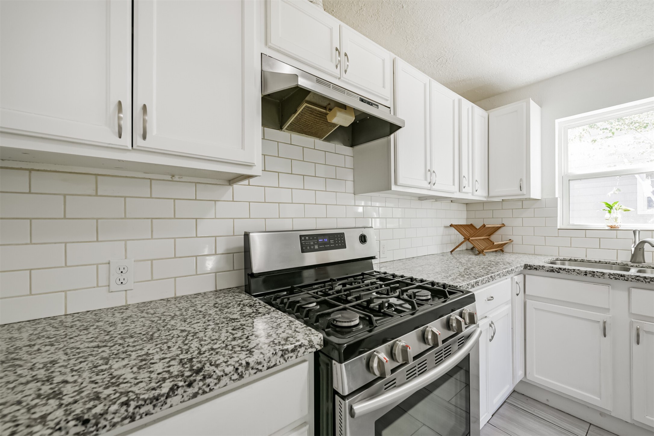 7546 Greendowns Street Houston, TX 77087 - Photo 21 of 33 a kitchen with white cabinets and appliances