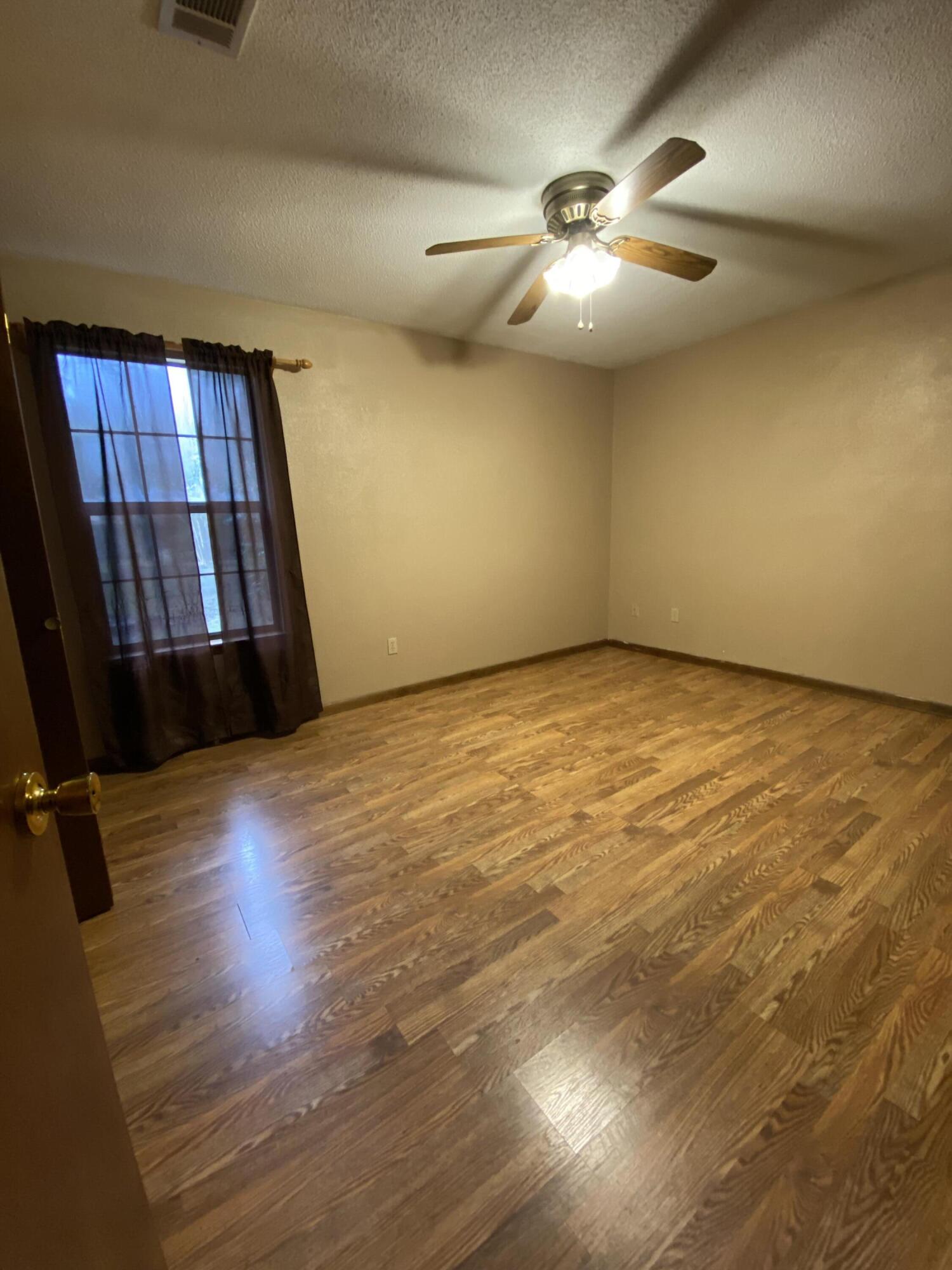 3170 Skyline Drive Crestview, FL 32539 - Photo 13 of 16 an empty room with windows and fan