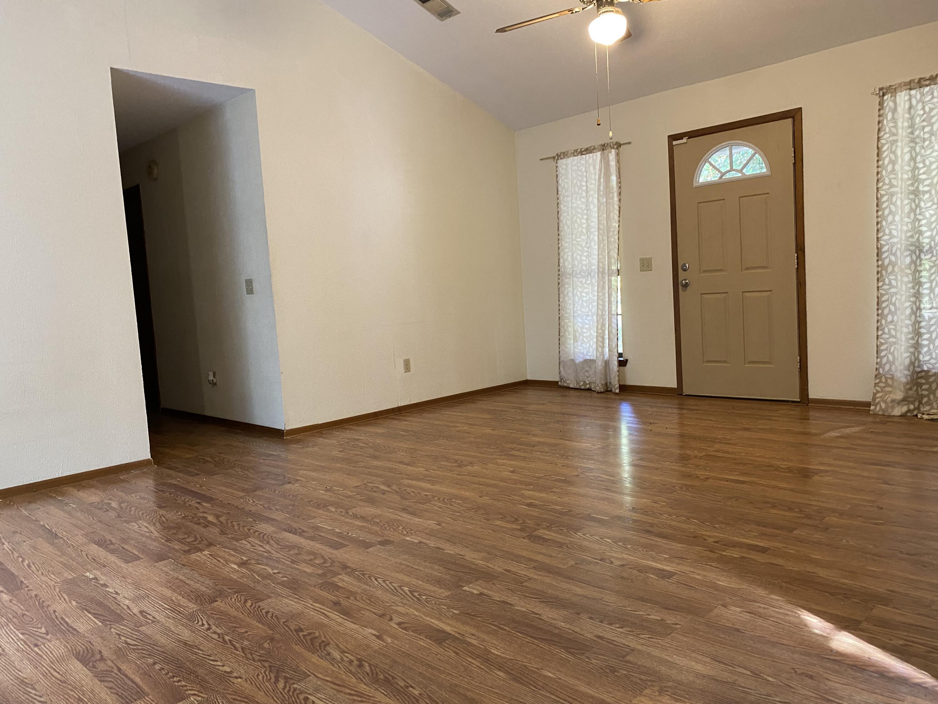 3170 Skyline Drive Crestview, FL 32539 - Photo 3 of 16 a view of an empty room with wooden floor and a window