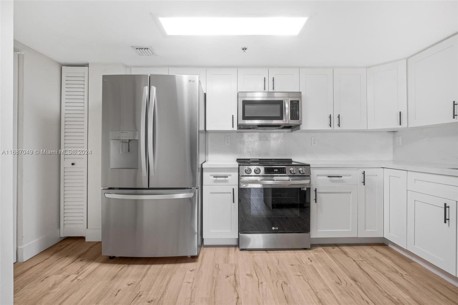 2351 Douglas Road, Unit 504 Miami, FL 33145 - Photo 13 of 41 a kitchen with stainless steel appliances a refrigerator stove and white cabinets