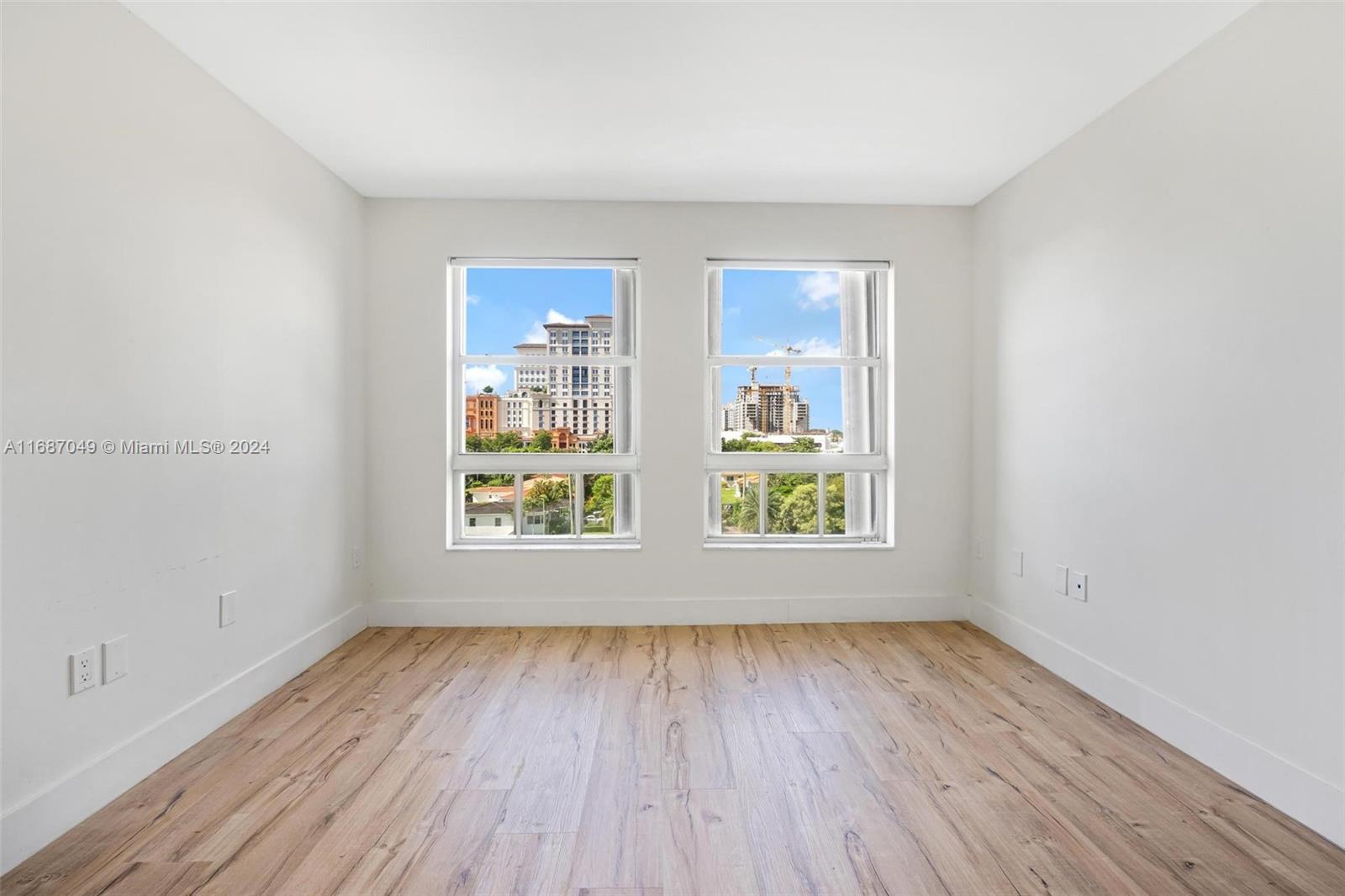 2351 Douglas Road, Unit 504 Miami, FL 33145 - Photo 23 of 41 an empty room with wooden floor and windows
