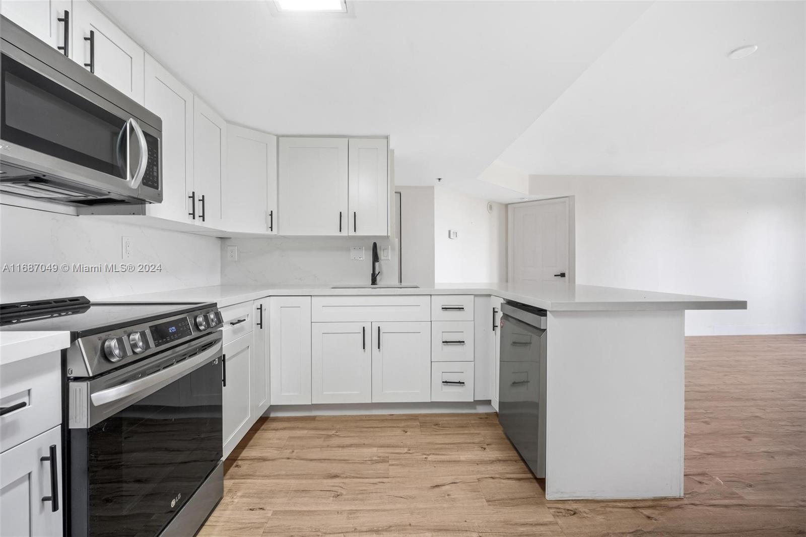 2351 Douglas Road, Unit 504 Miami, FL 33145 - Photo 4 of 41 a kitchen with cabinets stainless steel appliances and wooden floor