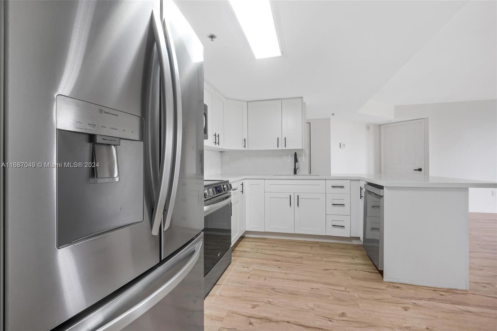 2351 Douglas Road, Unit 504 Miami, FL 33145 - Photo 5 of 41 a kitchen with white cabinets and stainless steel appliances