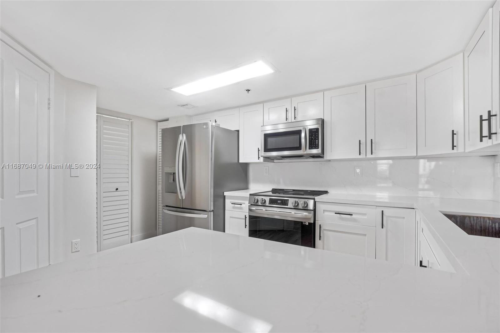 2351 Douglas Road, Unit 504 Miami, FL 33145 - Photo 7 of 41 a kitchen with granite countertop a refrigerator stove and sink