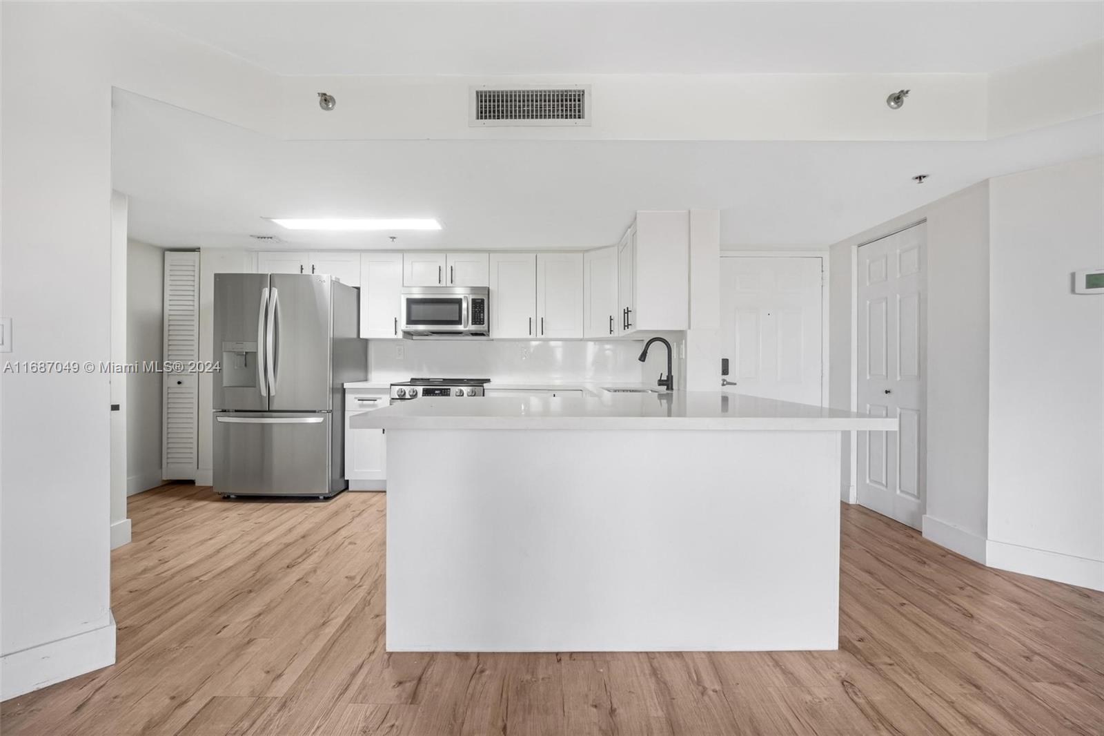 2351 Douglas Road, Unit 504 Miami, FL 33145 - Photo 8 of 41 a kitchen with stainless steel appliances a refrigerator sink and cabinets