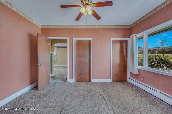 a view of a hallway with a chandelier fan and windows