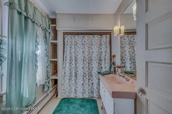 a bathroom with a sink a mirror and shower