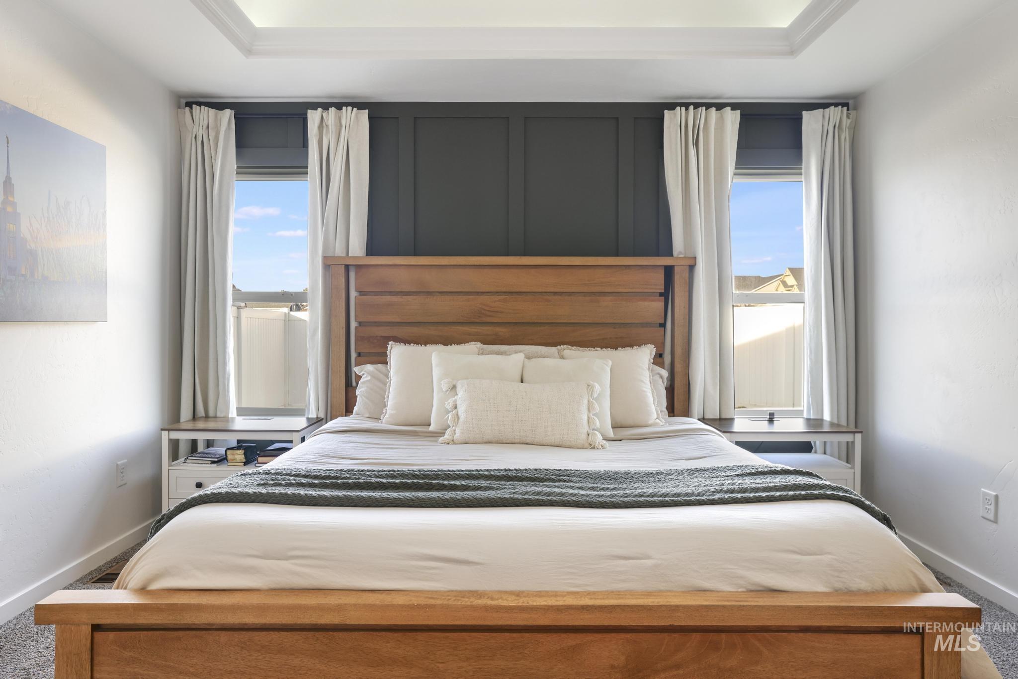 2396 Village Street Twin Falls, ID 83301 - Photo 26 of 44 Bedroom featuring light carpet, multiple windows, and a tray ceiling