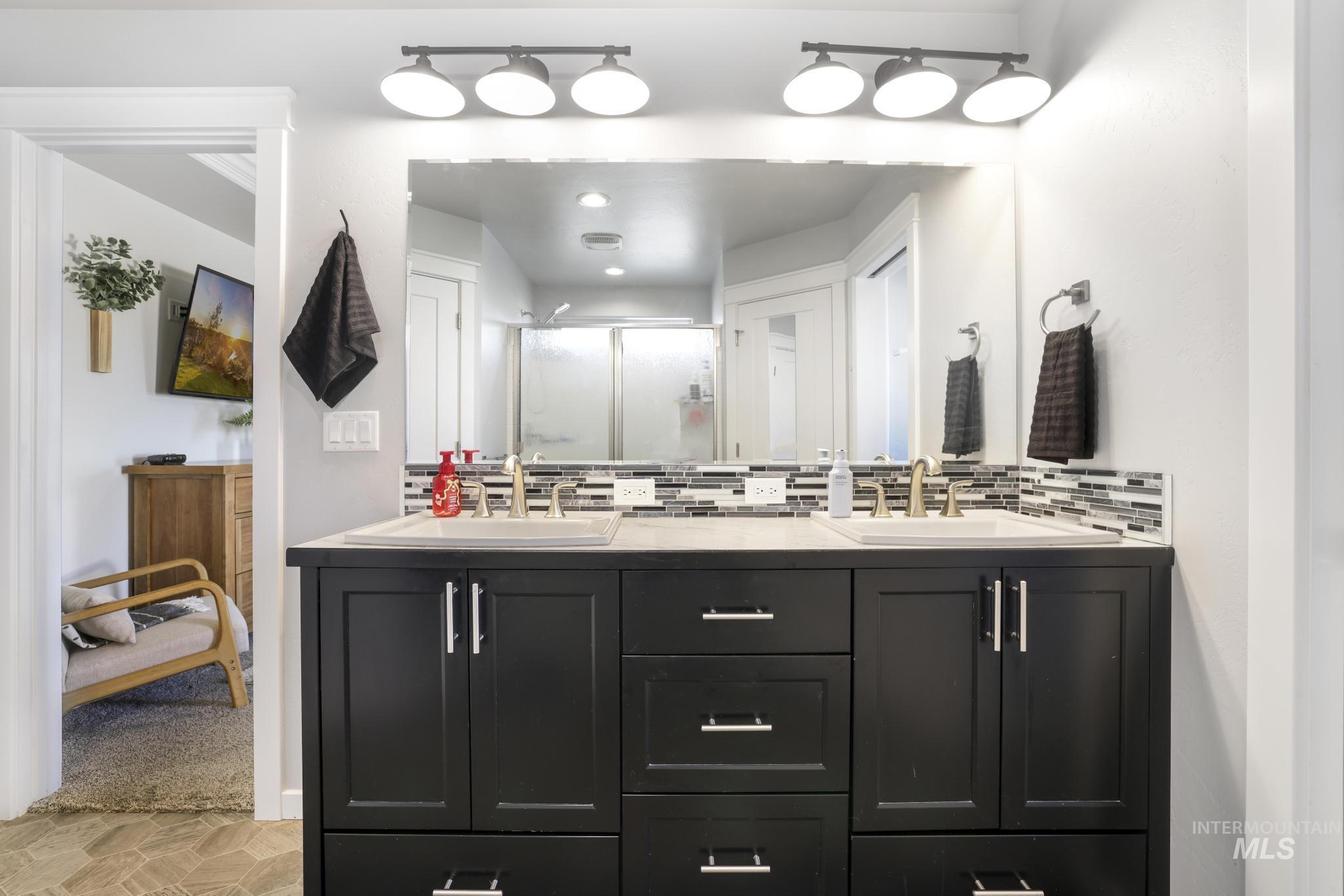 2396 Village Street Twin Falls, ID 83301 - Photo 29 of 44 Bathroom with double vanity, a shower stall, and tasteful backsplash