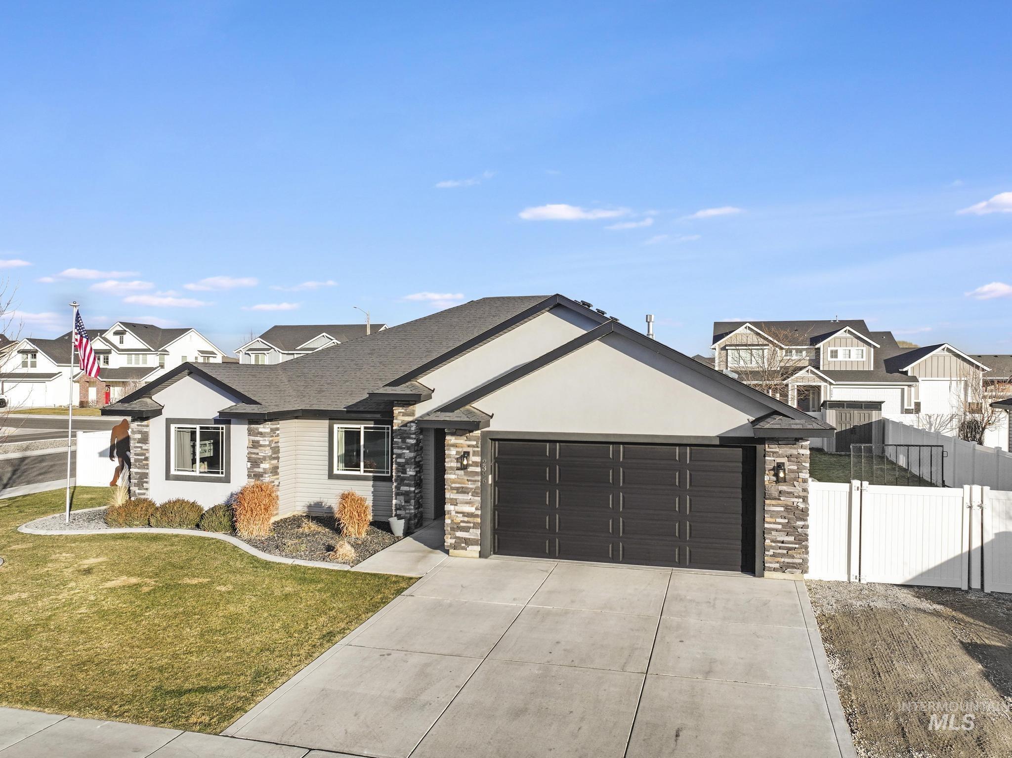 2396 Village Street Twin Falls, ID 83301 - Photo 3 of 44 View of front of property with concrete driveway, a residential view, an attached garage, and stone siding