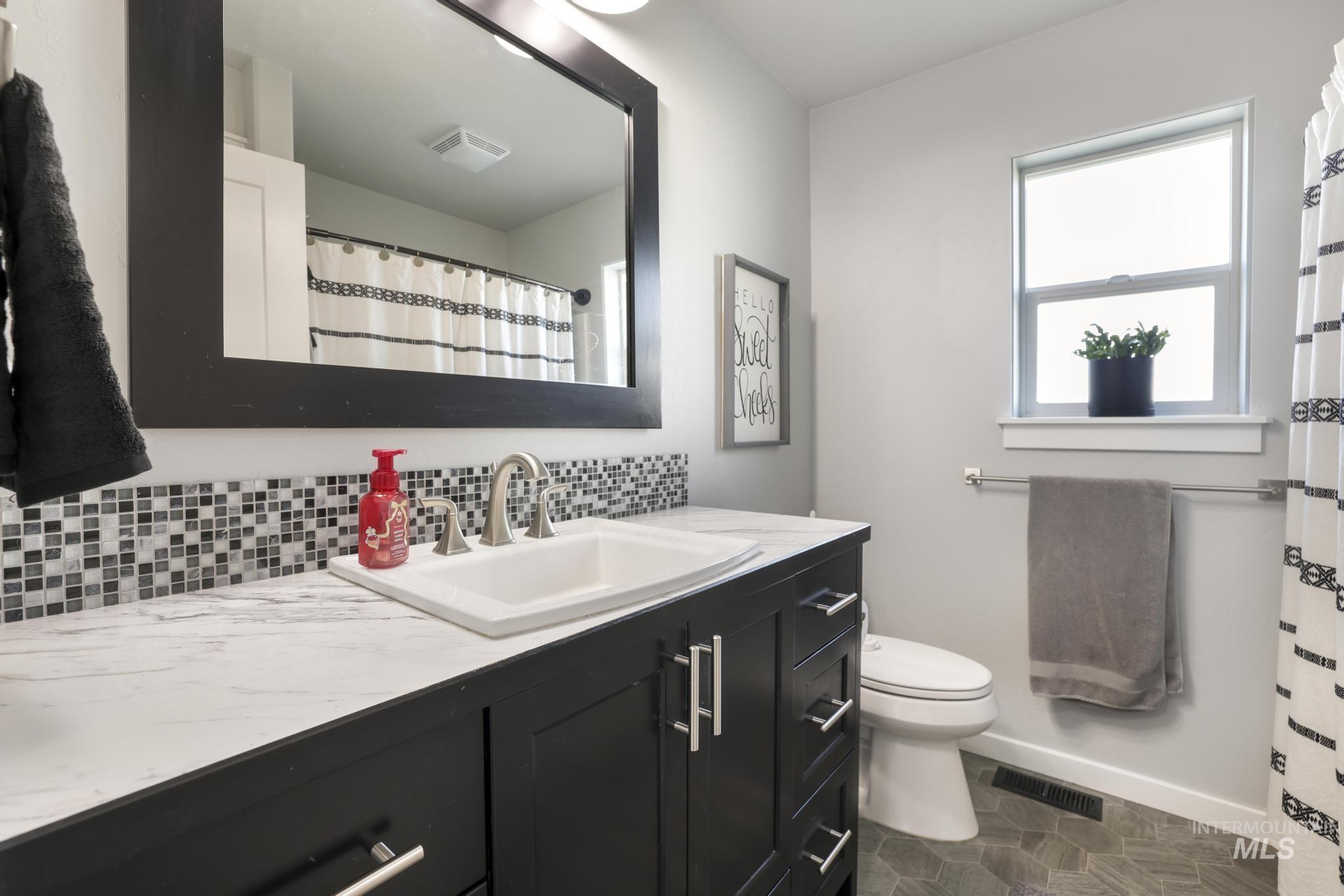 2396 Village Street Twin Falls, ID 83301 - Photo 32 of 44 Bathroom featuring vanity, a shower with curtain, and tasteful backsplash