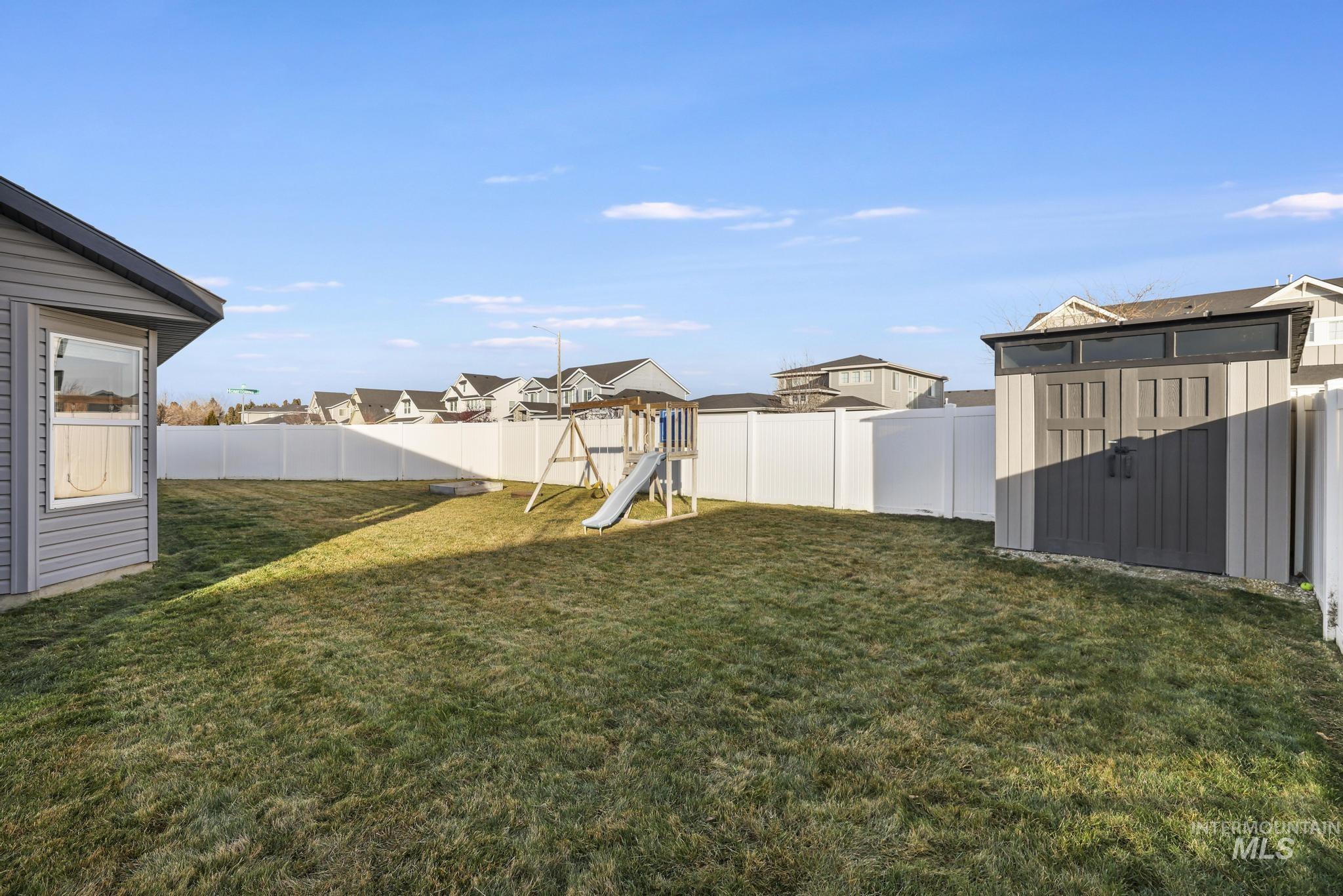 2396 Village Street Twin Falls, ID 83301 - Photo 38 of 44 Fenced backyard with a shed, a playground, and a residential view