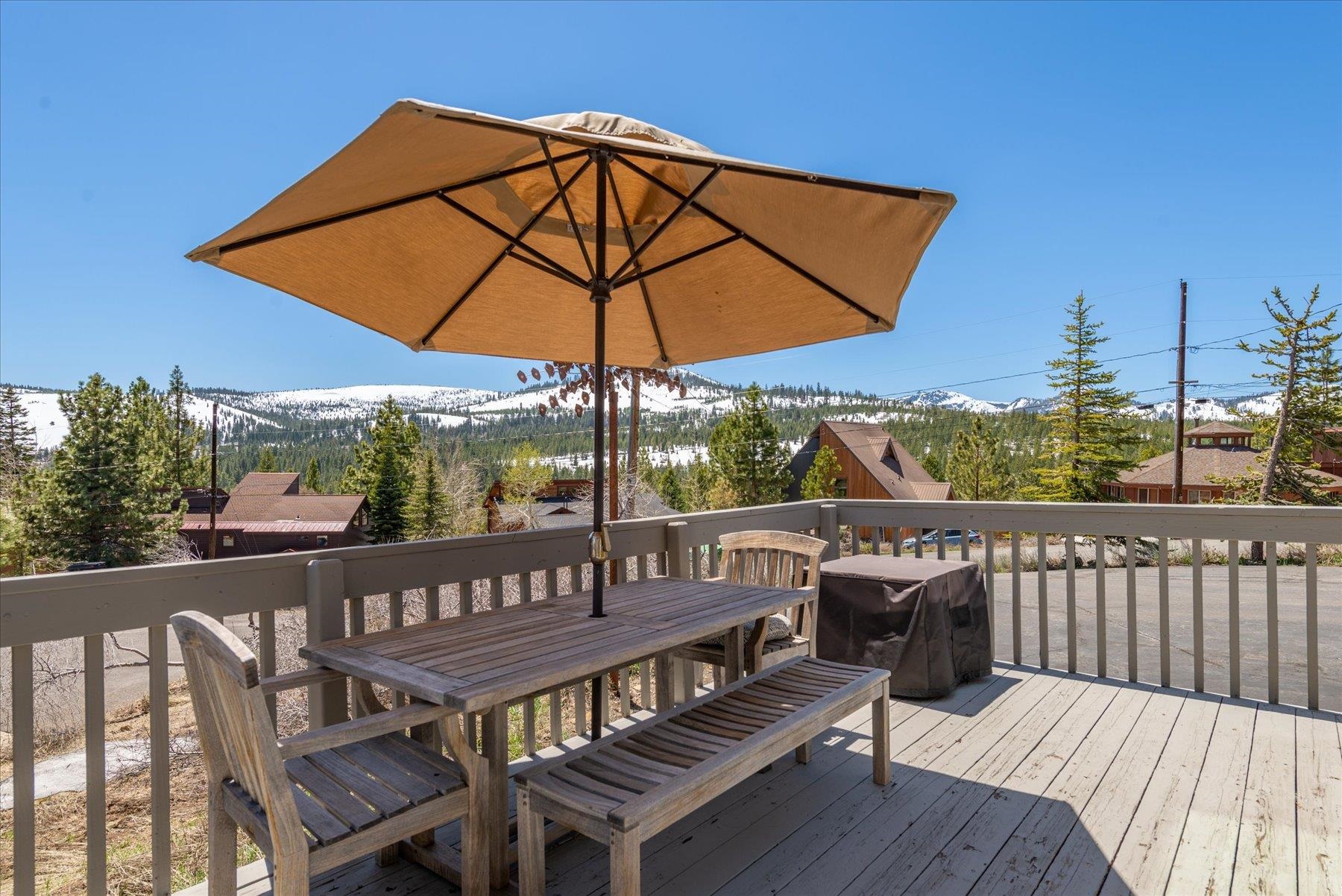 12676 Pinnacle Loop Truckee, CA 96161 - Photo 3 of 19 a view of a roof deck with table and chairs under an umbrella with wooden floor