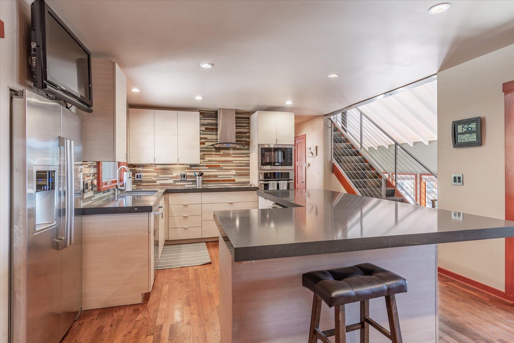 12676 Pinnacle Loop Truckee, CA 96161 - Photo 10 of 19 a kitchen with stainless steel appliances granite countertop a refrigerator a stove and a sink with wooden floor