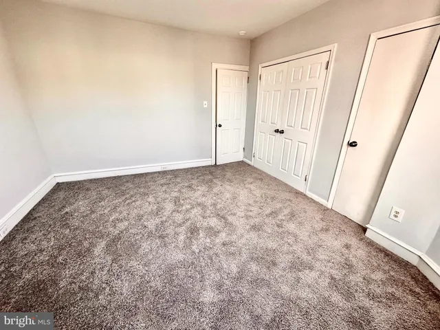 a spacious bathroom with a granite countertop sink a toilet a mirror and shower