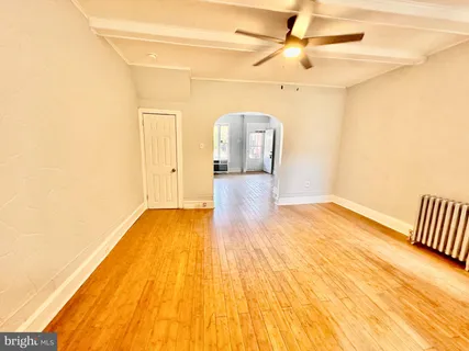 a view of a room with wooden floor and ceiling fan