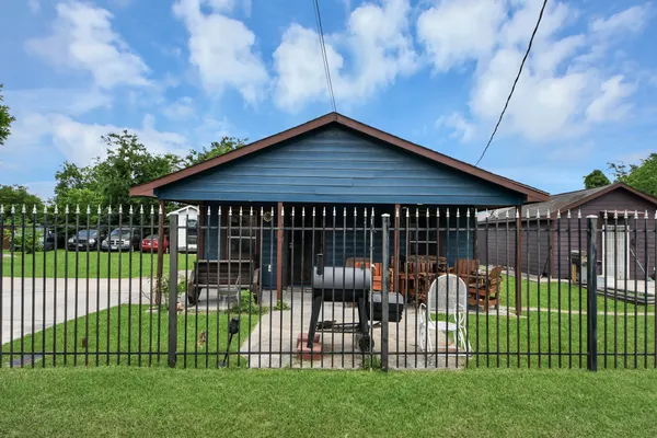 a view of a house with a small yard and wooden fence