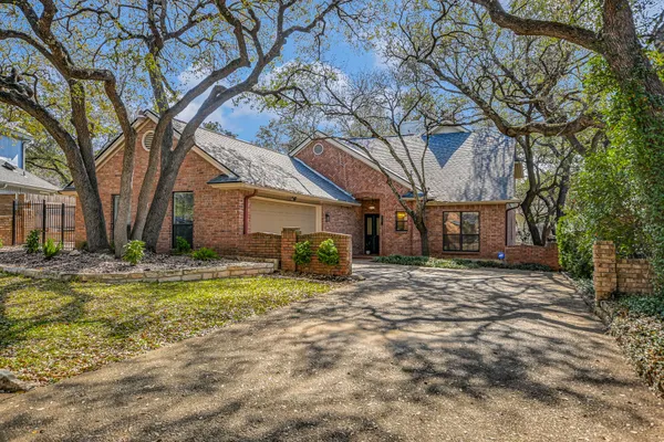 a view of a house with a large tree in front of it