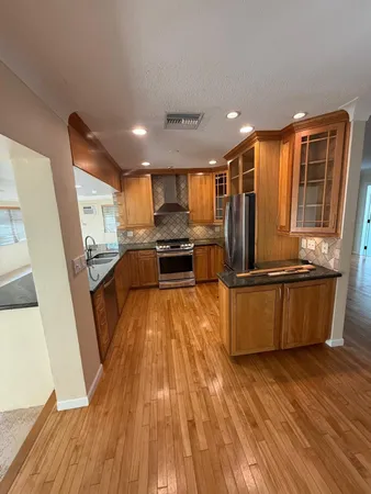 a kitchen with granite countertop a sink and wooden floor
