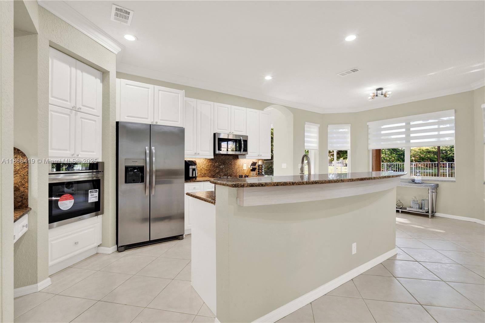18708 Ocean Mist Drive Boca Raton, FL 33498 - Photo 11 of 58 a kitchen with stainless steel appliances a refrigerator sink and cabinets
