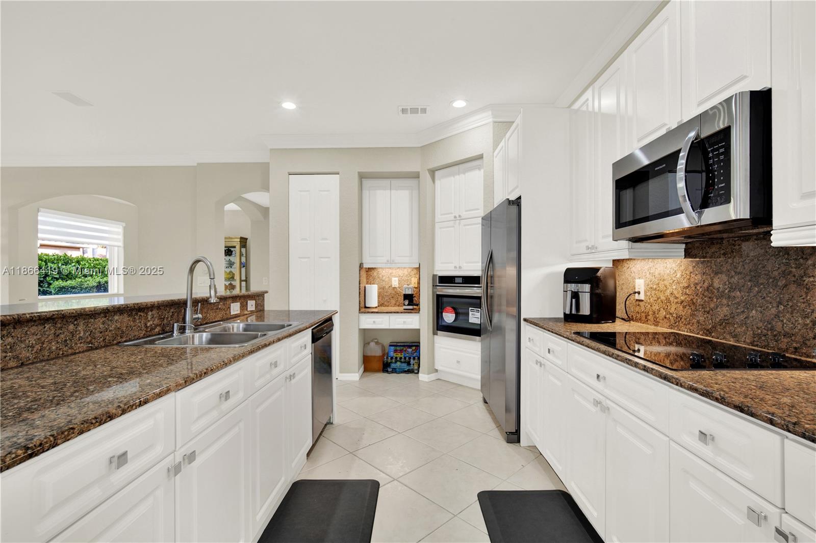 18708 Ocean Mist Drive Boca Raton, FL 33498 - Photo 12 of 58 a kitchen with stainless steel appliances granite countertop a sink and a stove