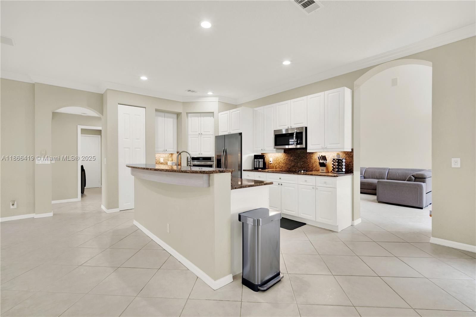 18708 Ocean Mist Drive Boca Raton, FL 33498 - Photo 13 of 58 a kitchen with white cabinets and stainless steel appliances