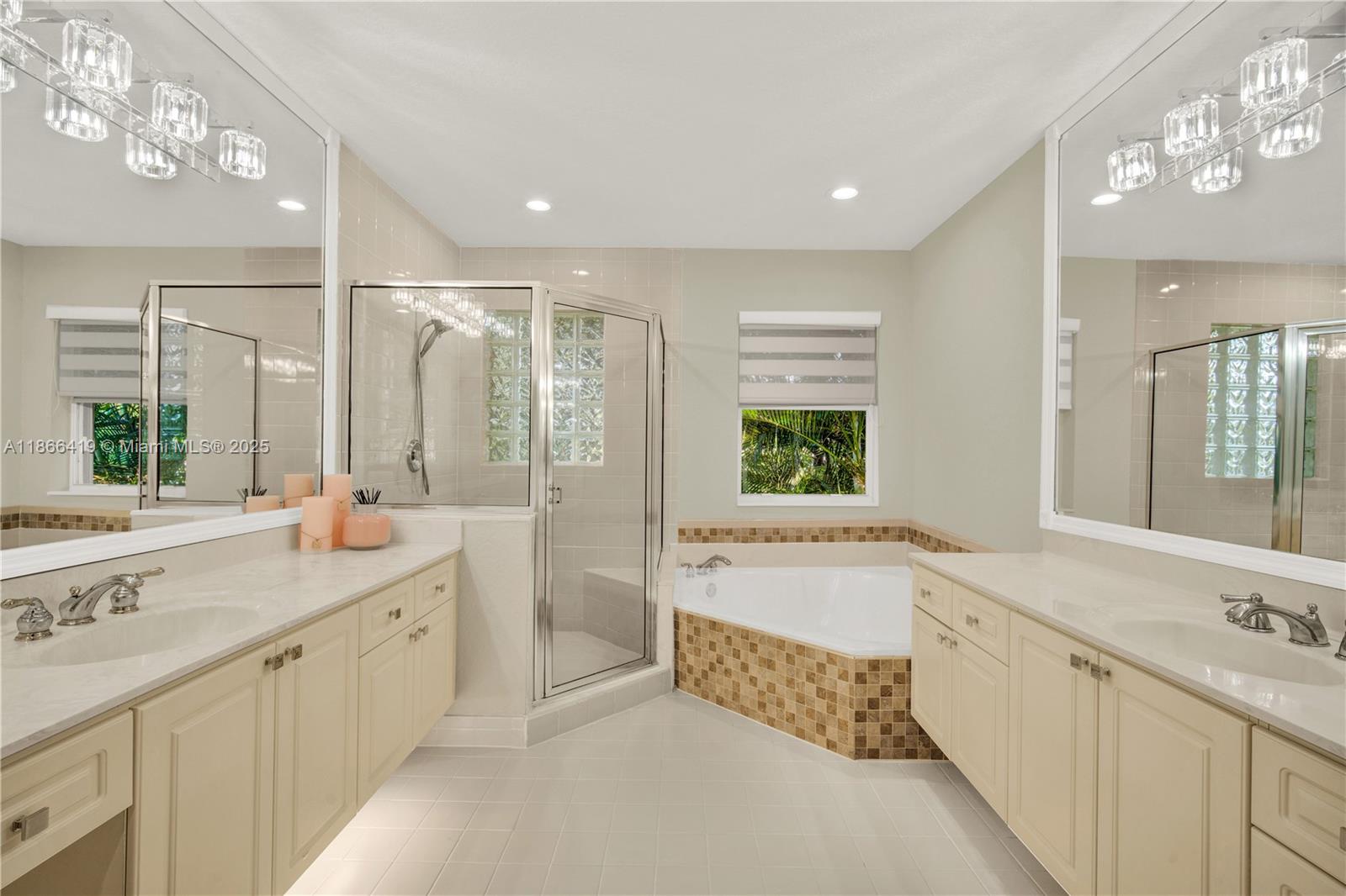 18708 Ocean Mist Drive Boca Raton, FL 33498 - Photo 30 of 58 a spacious bathroom with a double vanity sink a large mirror and a bathtub