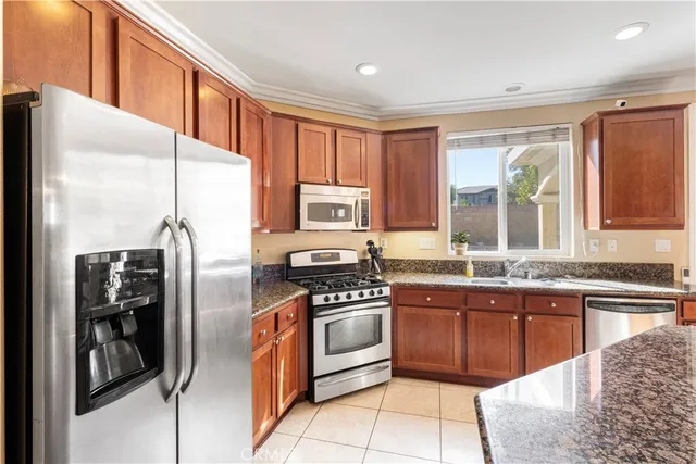 a kitchen with stainless steel appliances granite countertop a stove a sink and a refrigerator