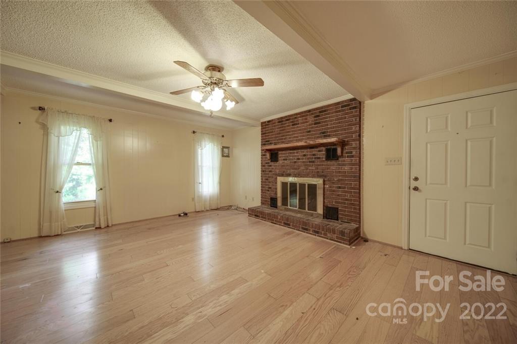 699 Bailey Road Lancaster, SC 29720 - Photo 3 of 43 an empty room with wooden floor fireplace and windows