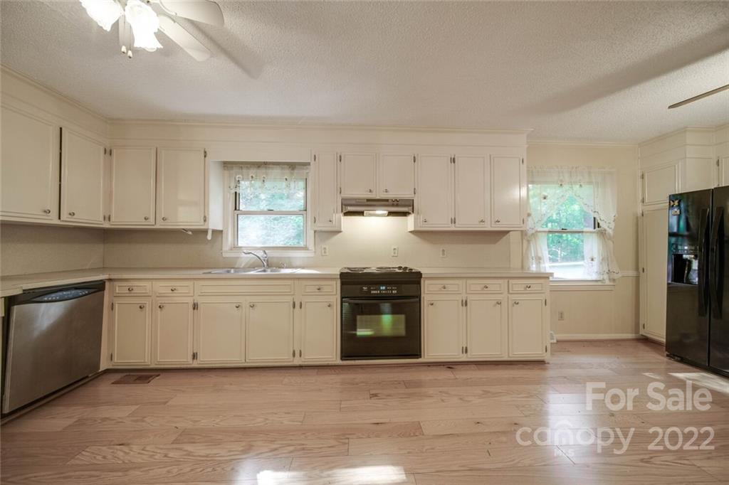 699 Bailey Road Lancaster, SC 29720 - Photo 6 of 43 a kitchen with granite countertop white cabinets a refrigerator a sink a stove and white cabinets