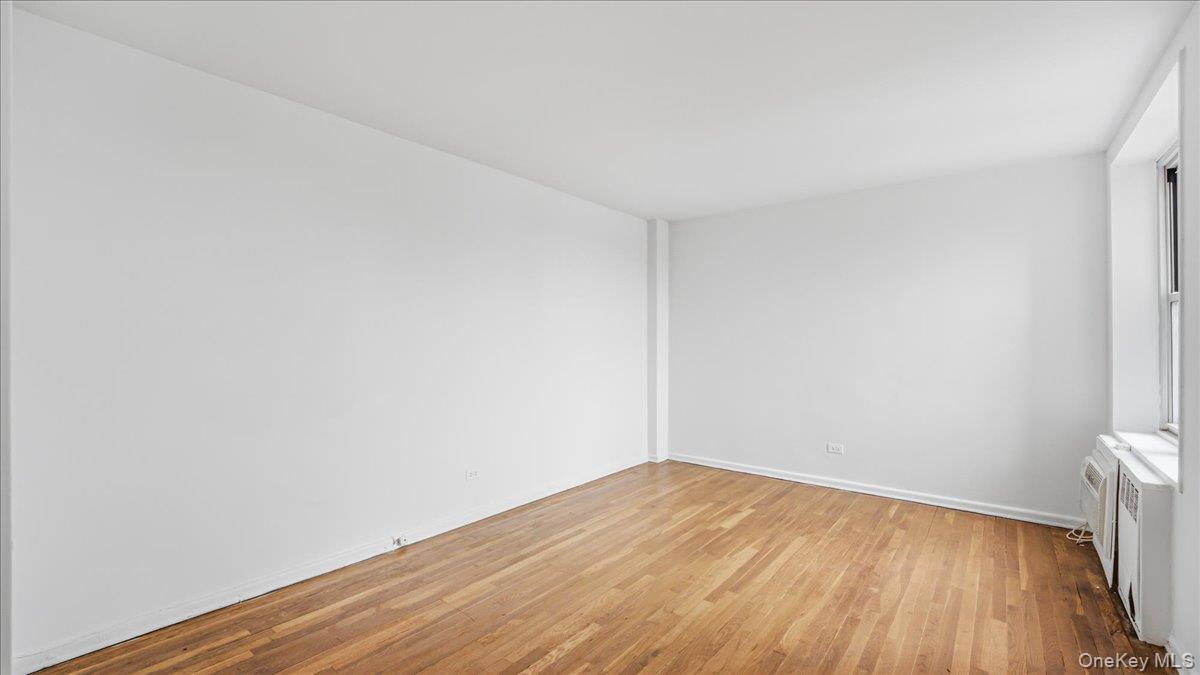 210-15 23rd Avenue, Unit 3F Queens, NY 11360 - Photo 19 of 24 a view of empty room with wooden floor