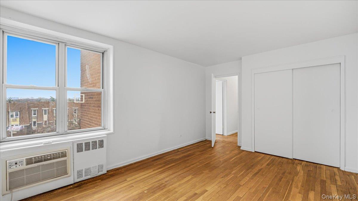 210-15 23rd Avenue, Unit 3F Queens, NY 11360 - Photo 21 of 24 a view of an empty room with wooden floor and a window