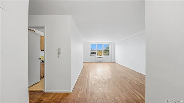 a view of a room with wooden floor and a window