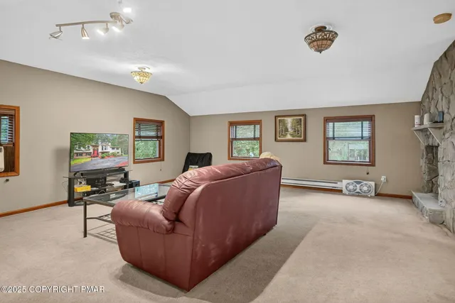 a living room with furniture a window and a flat screen tv