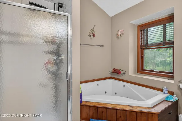 a bathroom with a tub a sink and a window
