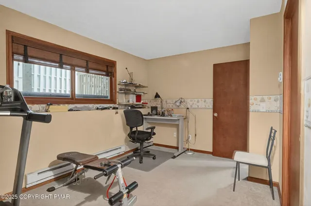 a view of a workspace with furniture and a window