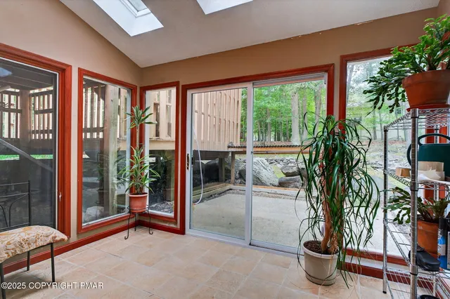 a living room with furniture a potted plant and a large window
