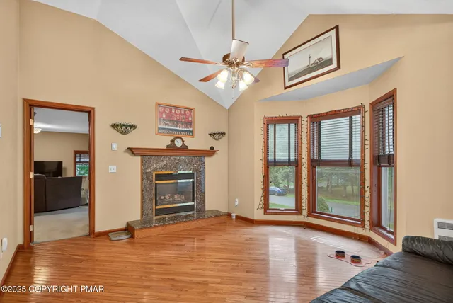 a view of an empty room with window and wooden floor
